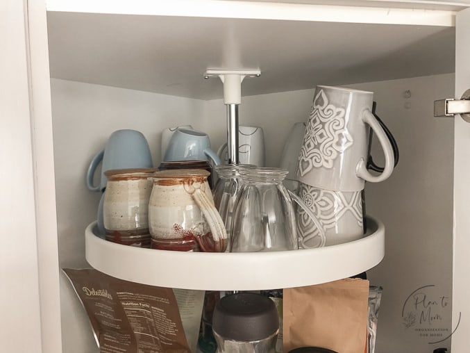 coffee cups sitting on the top shelf of a built-in corner lazy susan cabinet