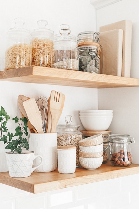 brightly lit image displaying kitchen supplies on wooden floating shelves